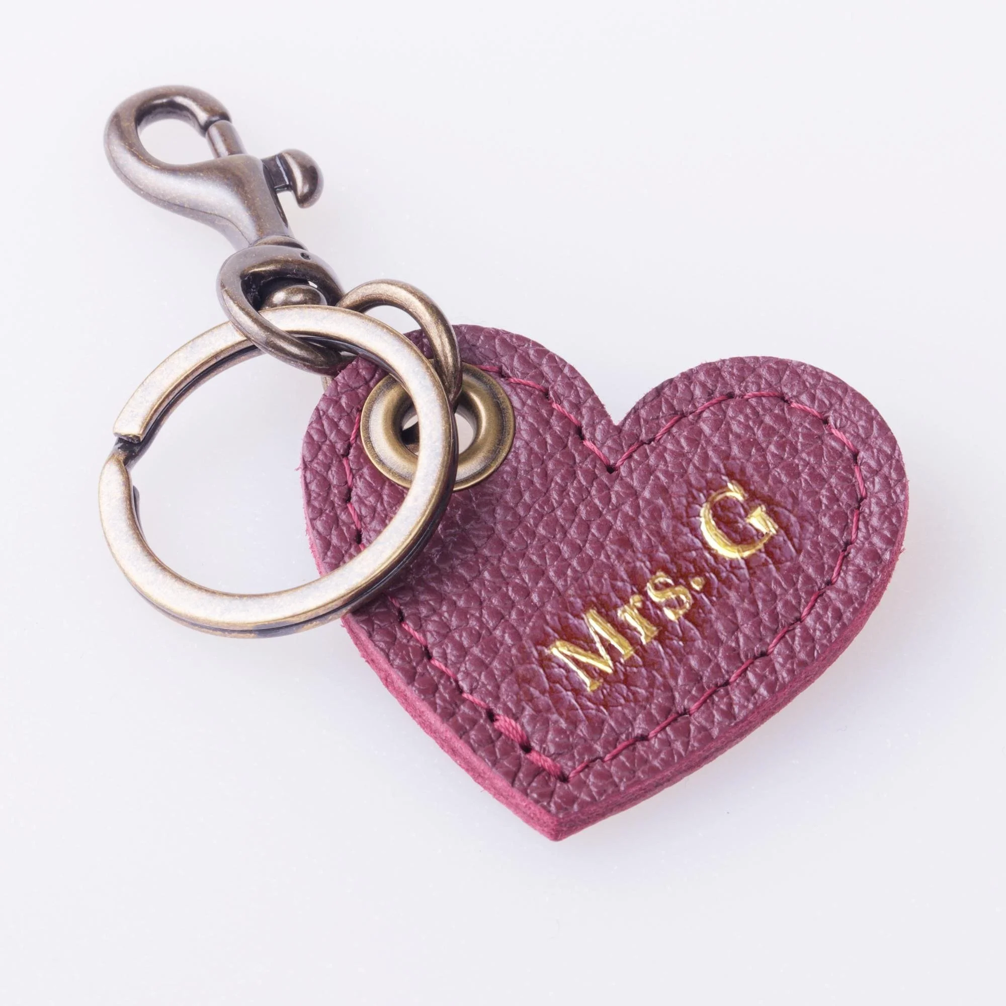 Personalized burgundy leather heart shaped keychain with antique brass finish hardware.