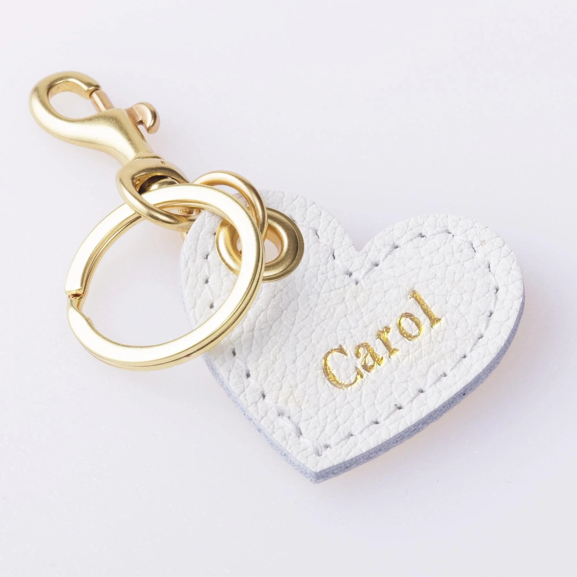 Personalized white leather heart shaped keychain with gold finish hardware.