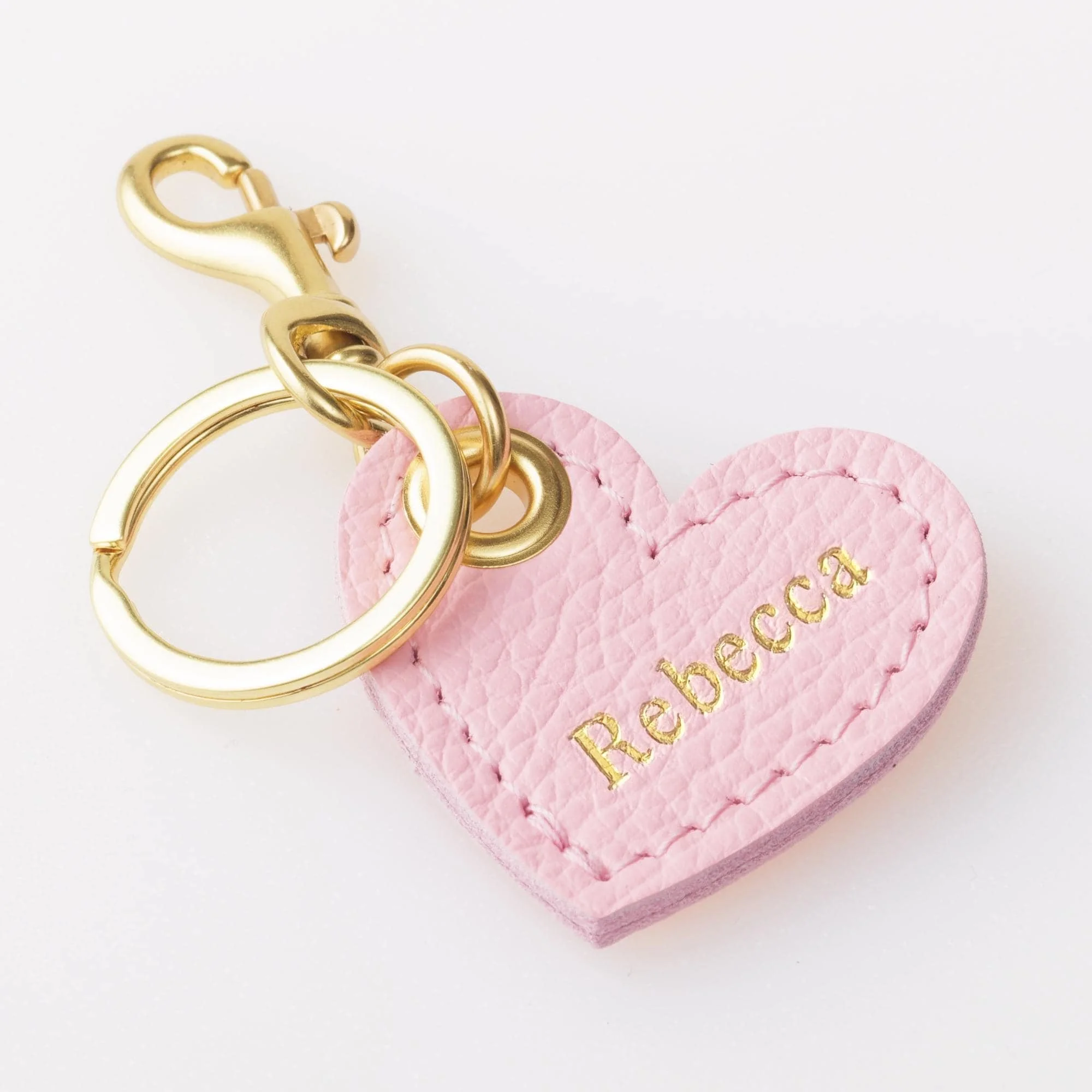 Personalized pink leather heart shaped keychain with gold finish hardware.