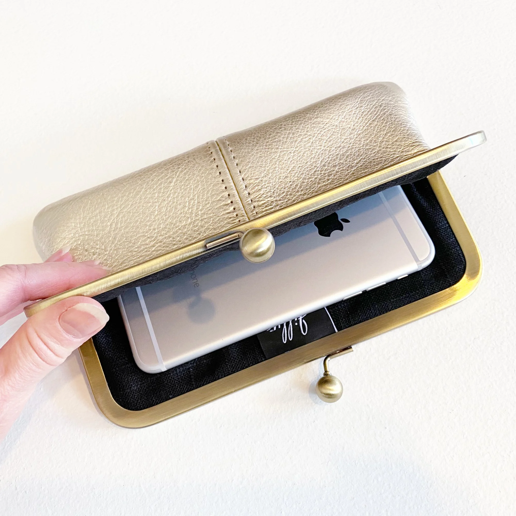 Metallic Platinum Leather Kiss Lock Clutch Interior View with Cell Phone.jpg
