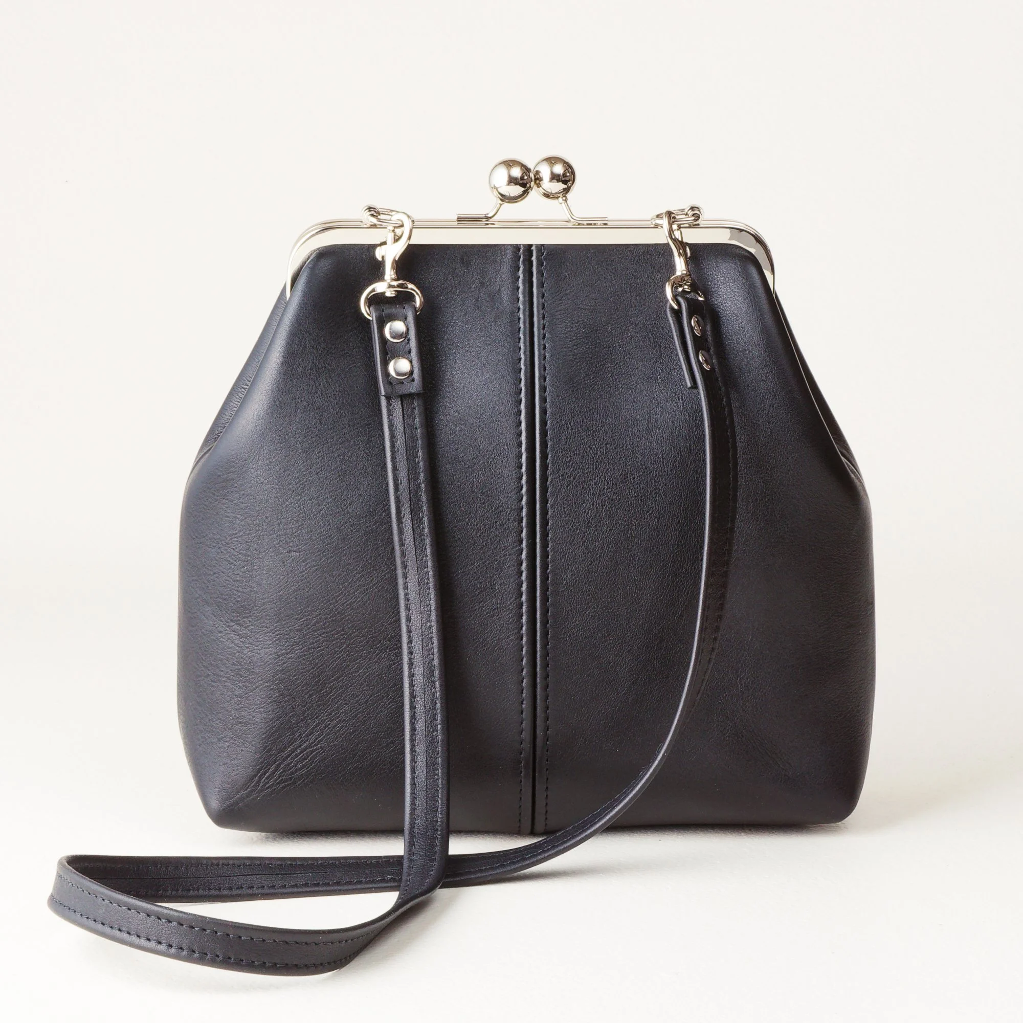 Crossbody Strap 8 inch Kiss Lock Handbag on Tabletop