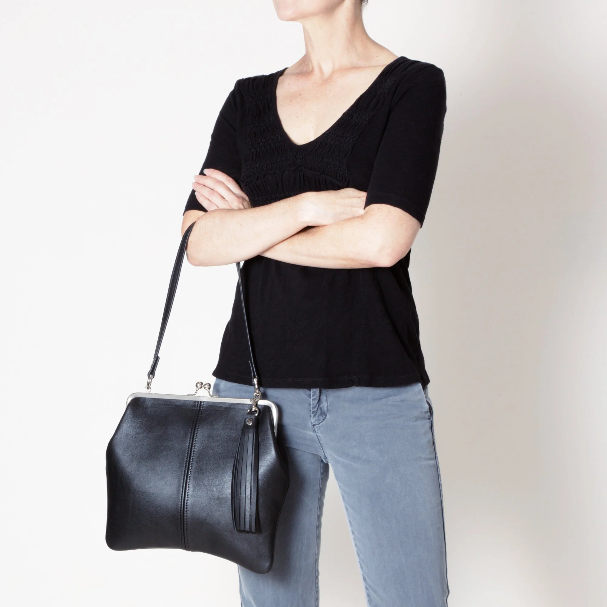 Model Holding Kiss Lock Closure Handbag with Standard Strap