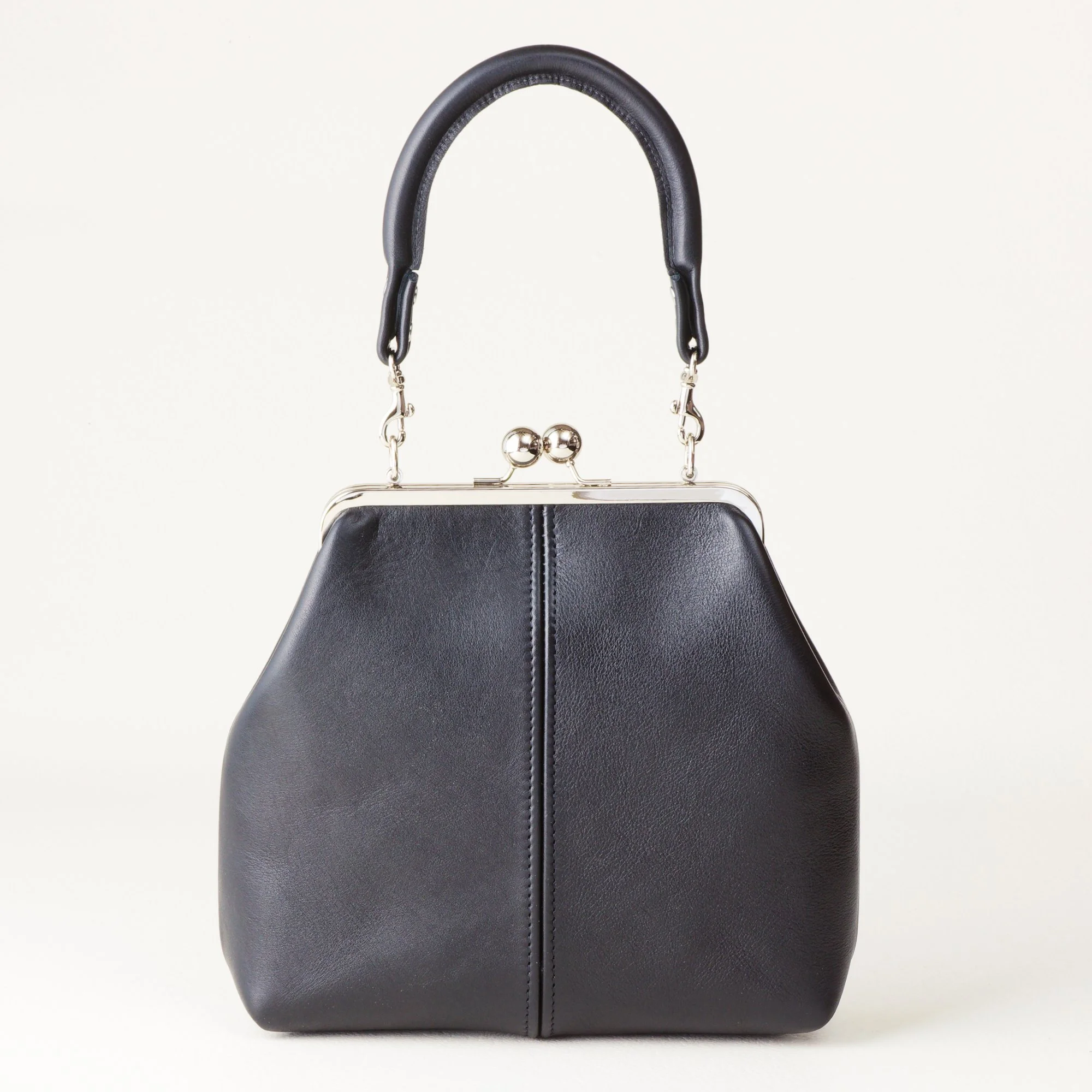 Rolled Handle 8 inch Kiss Lock Handbag on Tabletop