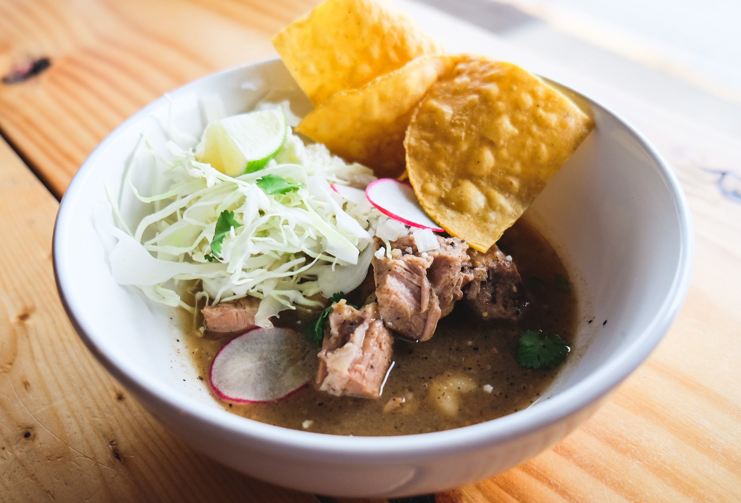 Pozole Verde Bowl: Pork Shoulder, Roasted Tomatillo-Chile Poblano Broth, Radish, Cilantro, Cabbage, Lime, Queso Fresco, Tortilla Chips