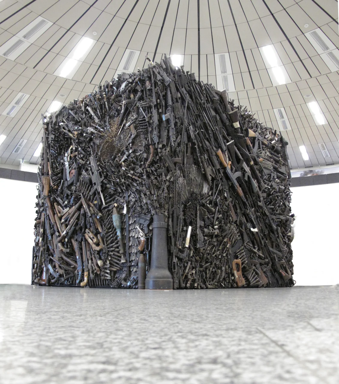 Gun Sculpture , Installation, co created with Wallis Kendal, 2000, three components, a) deactivated weapons, steel, concrete, 5 ton, b) lumex, photography, text c) wall sized blackboard, chalk, variable size