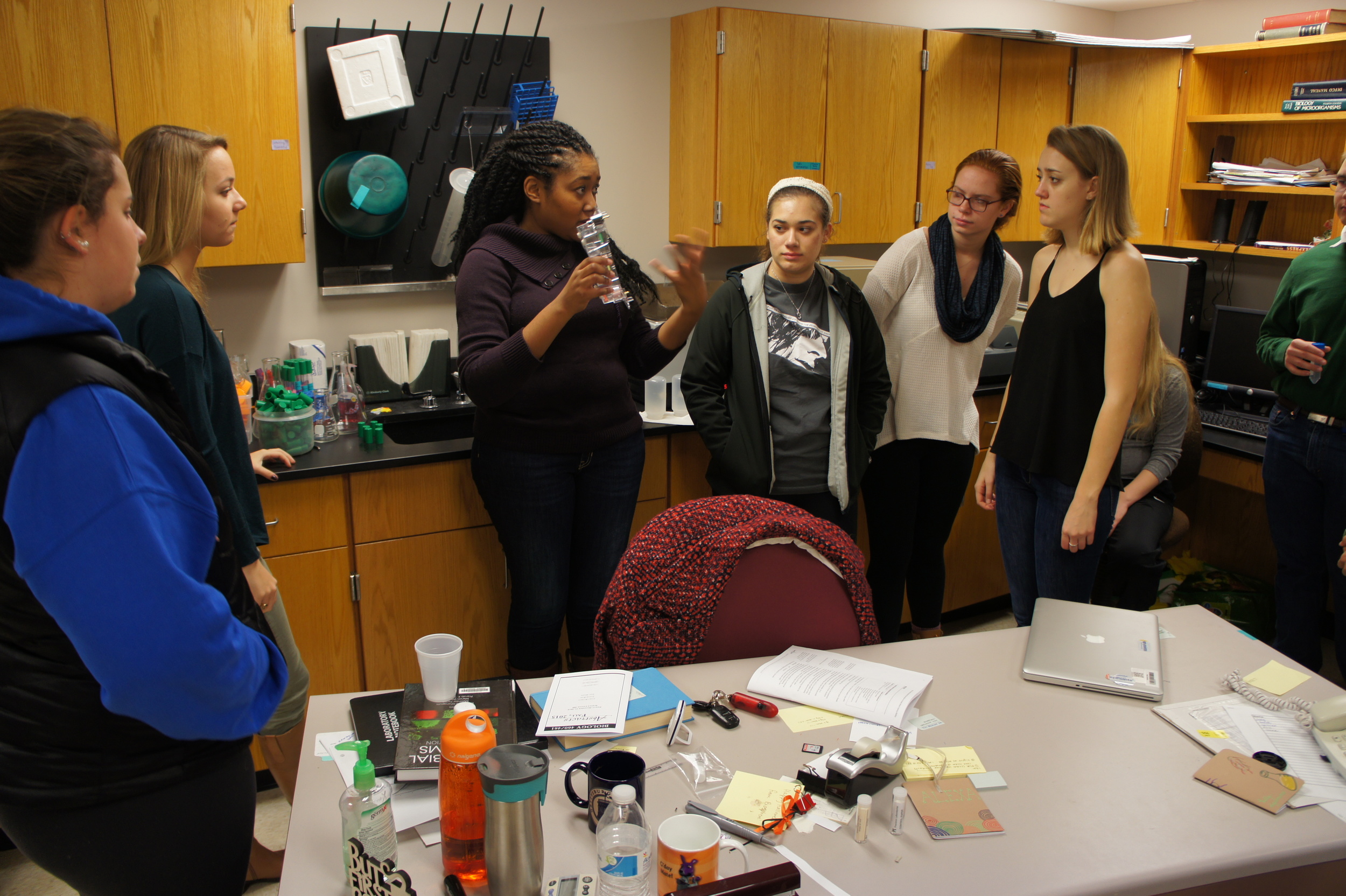 Dr. Zakiya Whatley, scientist and educator, explaining experiment to small group of students.