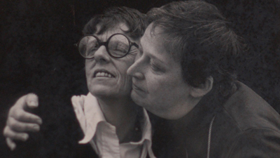 a black and white photo of two women embracing