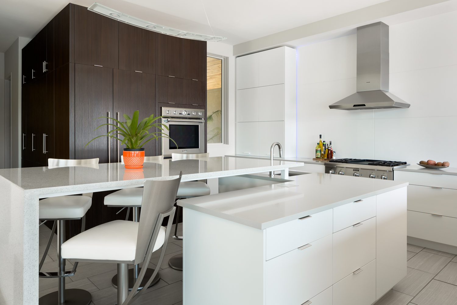 Loved the kitchen so much. The strong contrast to the dark wood and white cabinets, the sleek lines, the natural light and the added light accents just made for an incredible space! The huge walk in pantry is in the large wood cabinet.