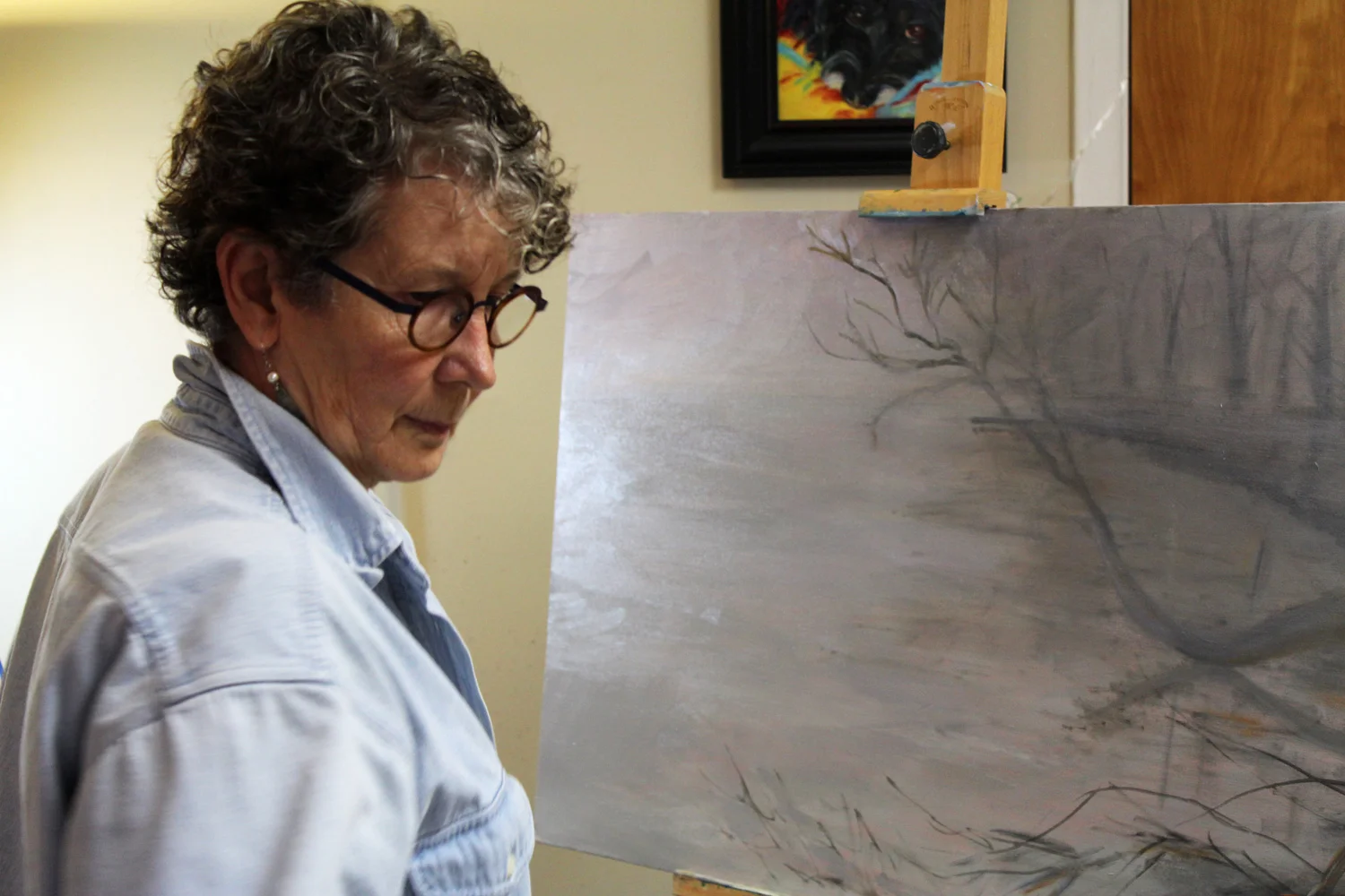 Fine Artist, Phyllis Sharpe, painting a waterscape in oil, in her studio