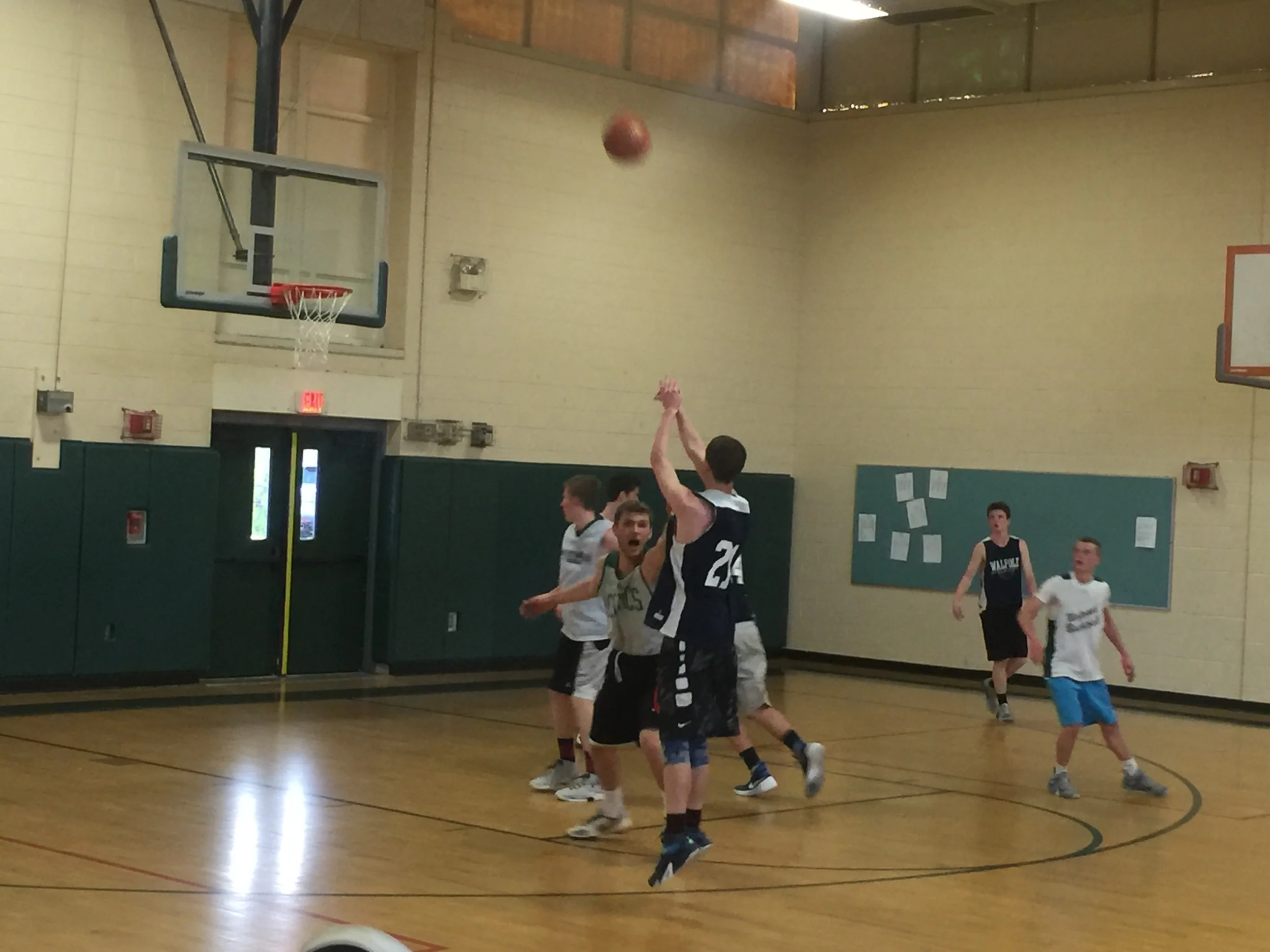 Walpole's Jordan Washburn hits a top of the key 3 over NESB 17U teammate Chuck Bemis .