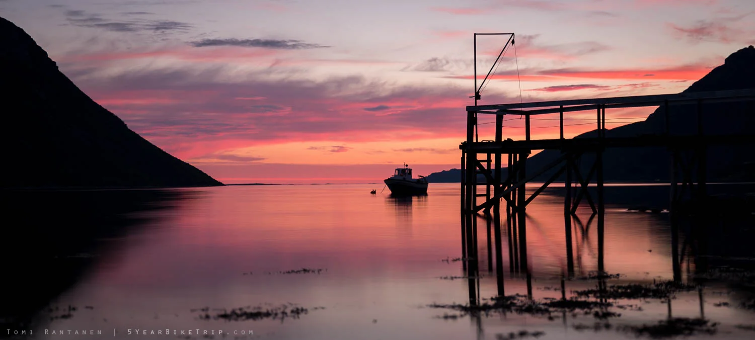 Fishing boat by a pier at sunset in Norway.