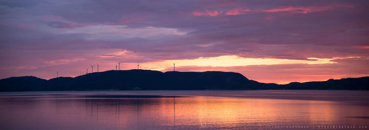 Wind turbines on a hill at sunset.