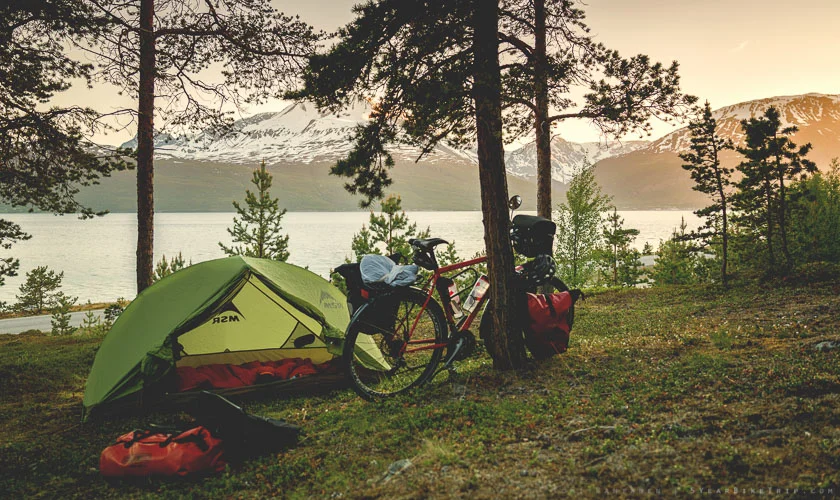 Tent by the fjord and mountains of Skibotn, Norway.