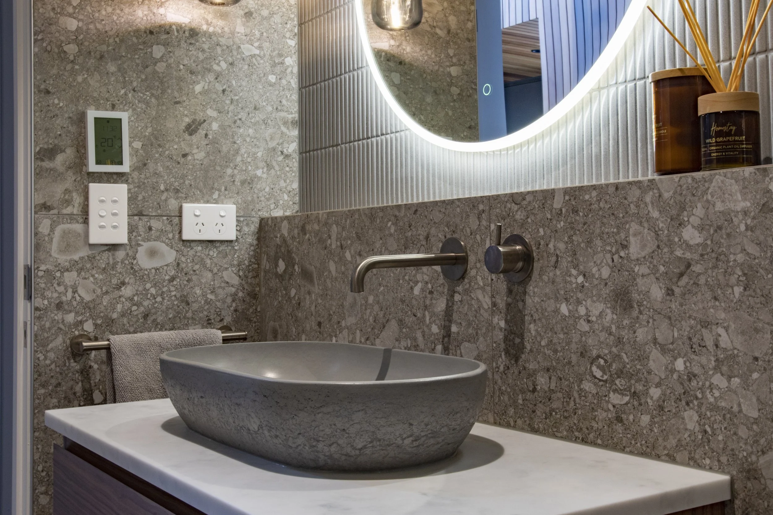 Grey vessel basin with wall mounted basin mixer