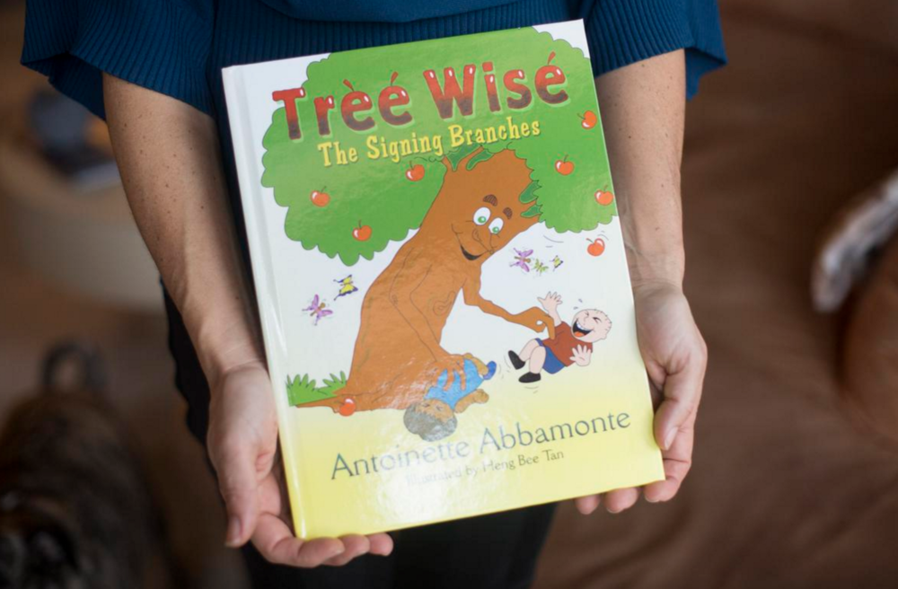  Antoinette Abbamonte holds a copy of her book "Tree Wise" at her home in Huntington Beach. Photography by Drew A. Kelley, Contributing Photographer. 