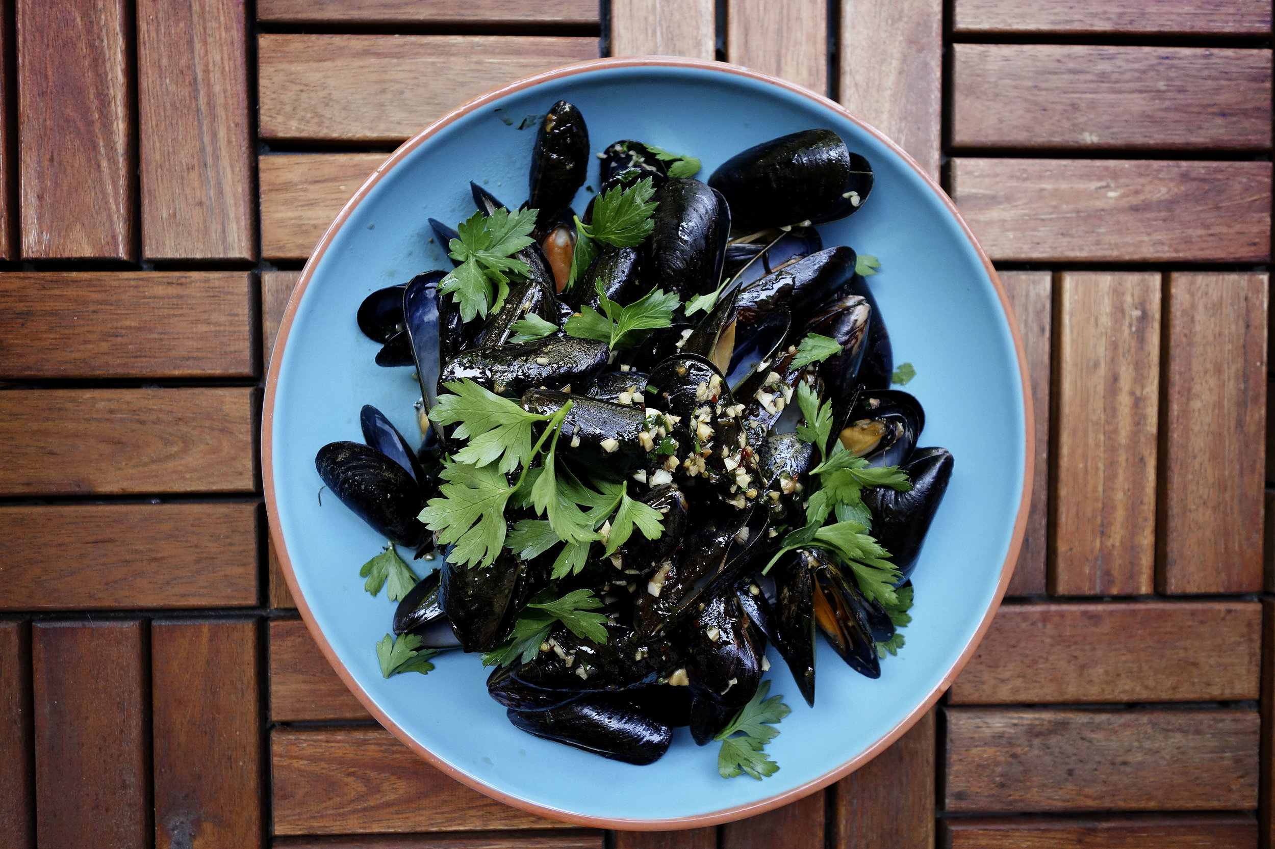 Mussels topped with parsley.