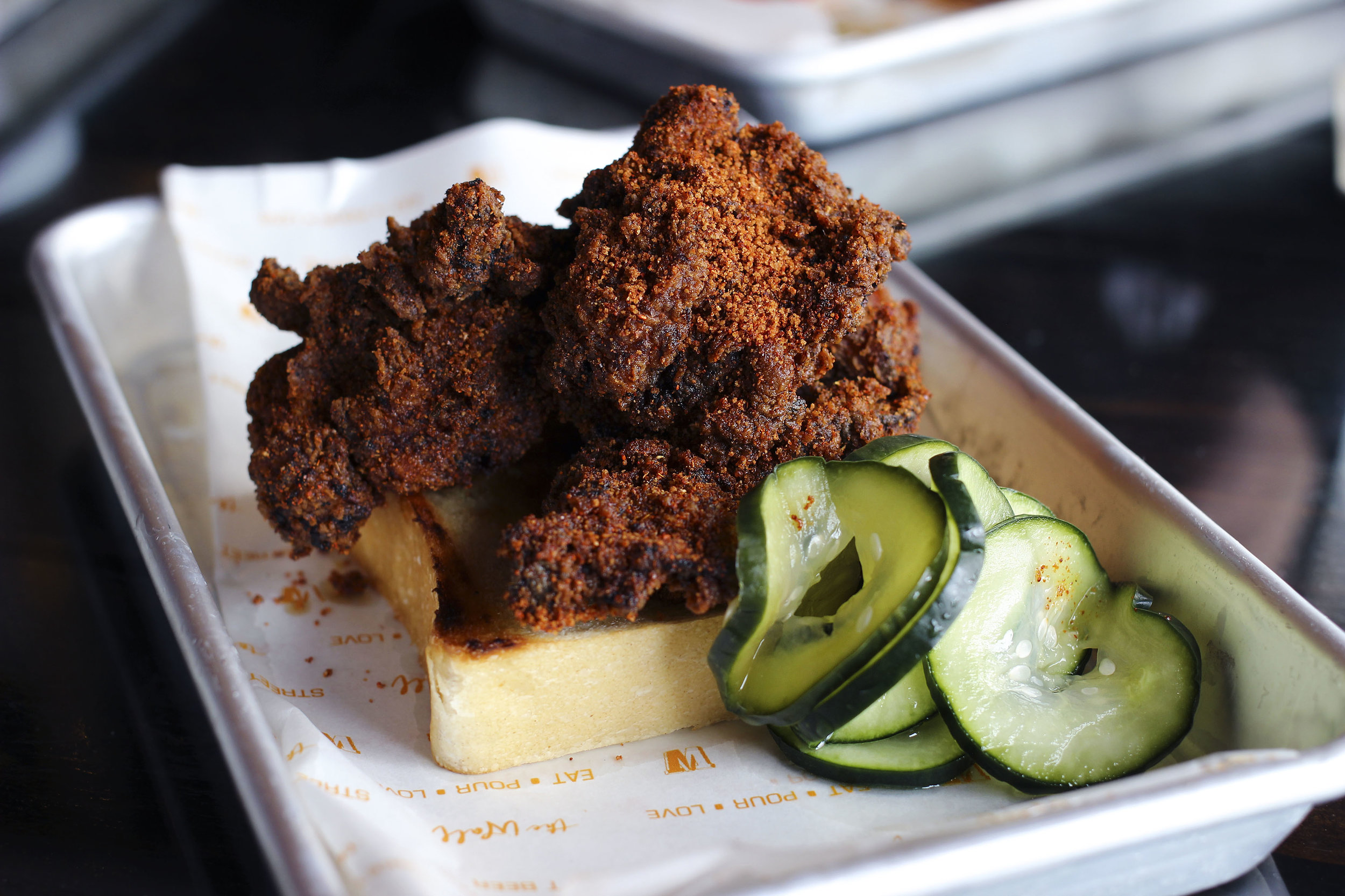 Their version of hot chicken over white bread served with house pickles.