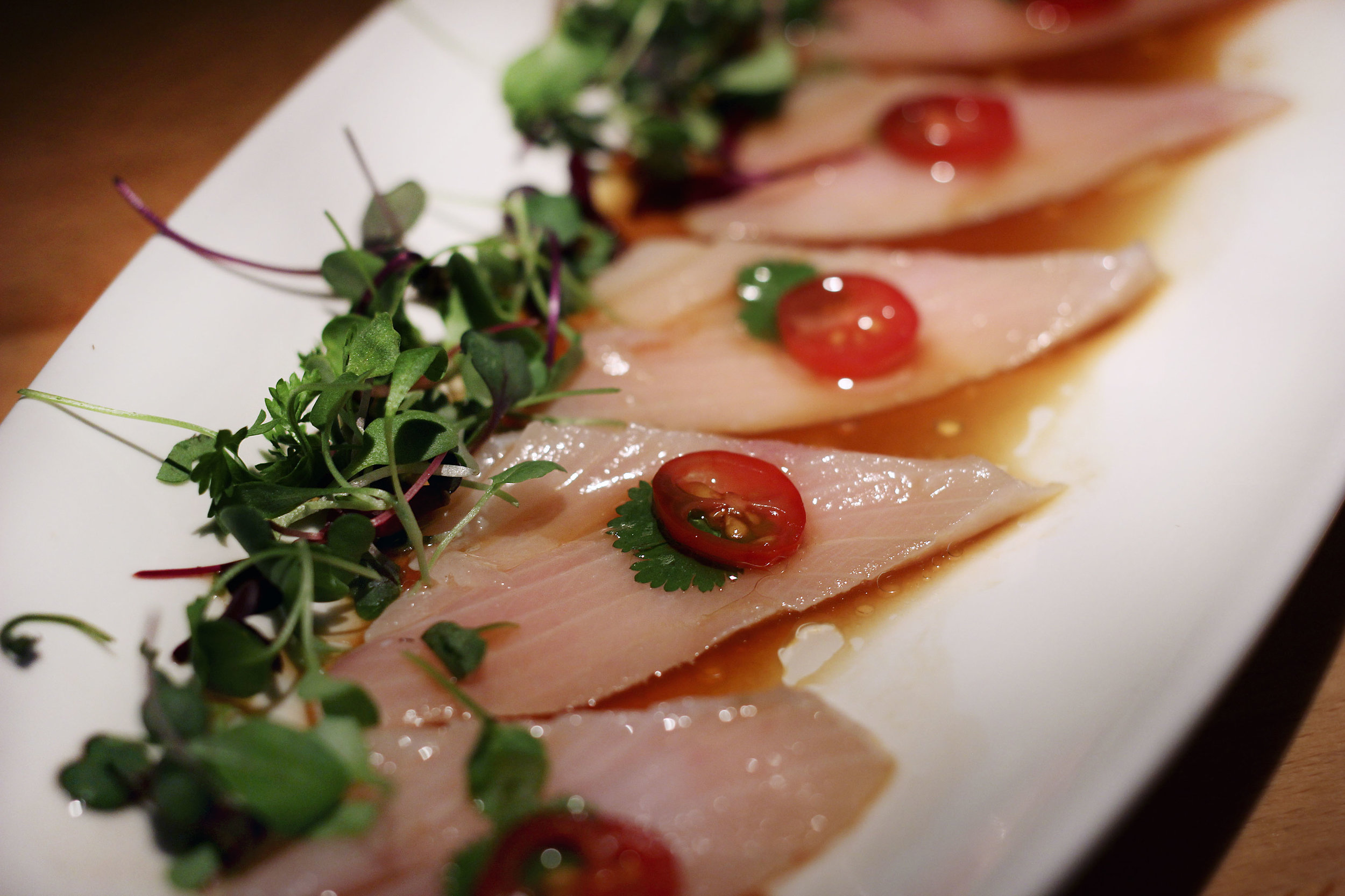 Yellowtail Carpaccio - Yuzu Citrus Sauce, Cilantro, Olive Oil, Tomato Micro Greens.