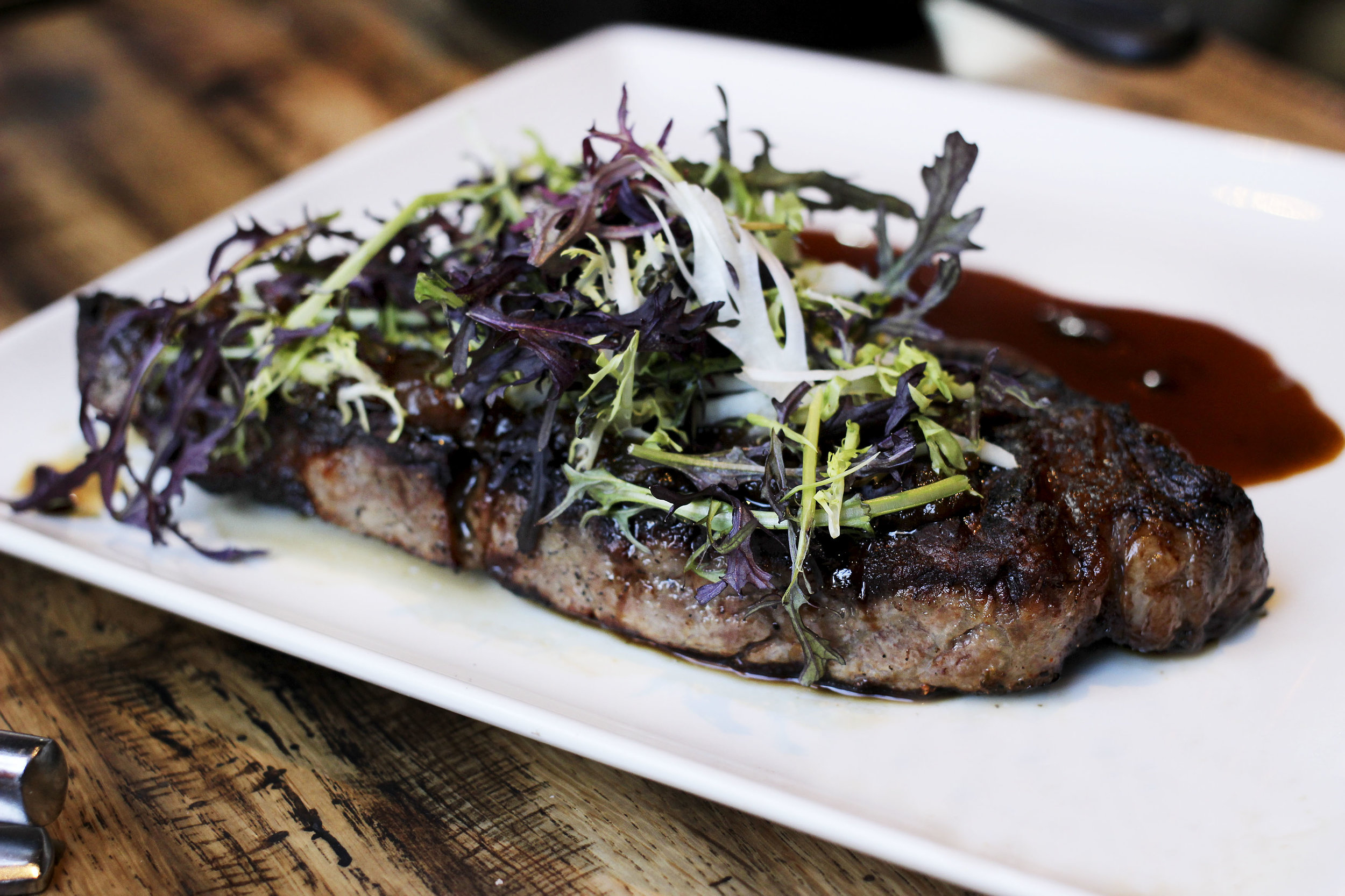 Prime NY Strip - 14 oz, charred onion-thyme jam, green peppercorn-cognac jus. Cooked Medium Rare.