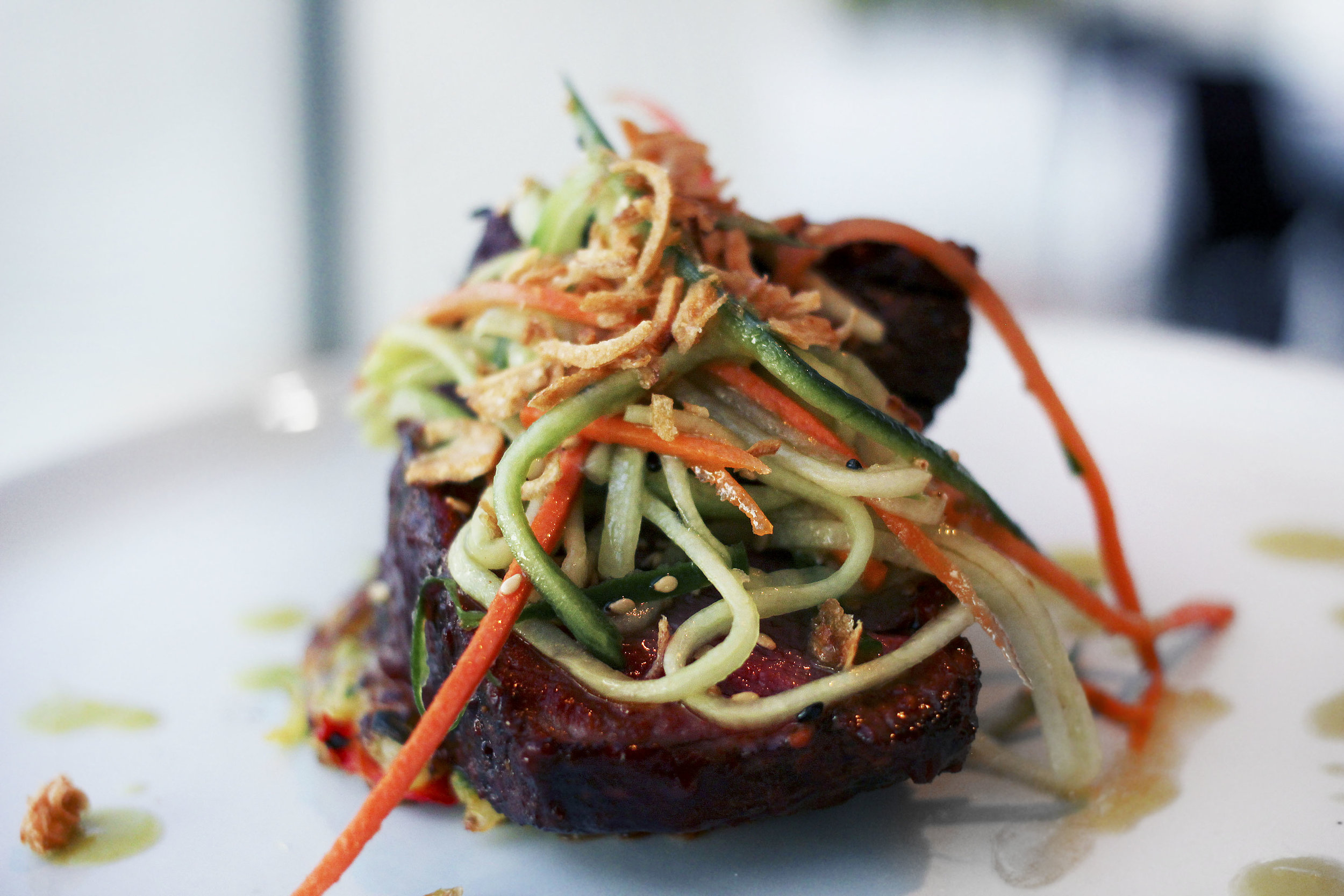 PRIME FILET OF BEEF - potato pancake, spicy sweet glaze, crispy onion, pickled vegetables.