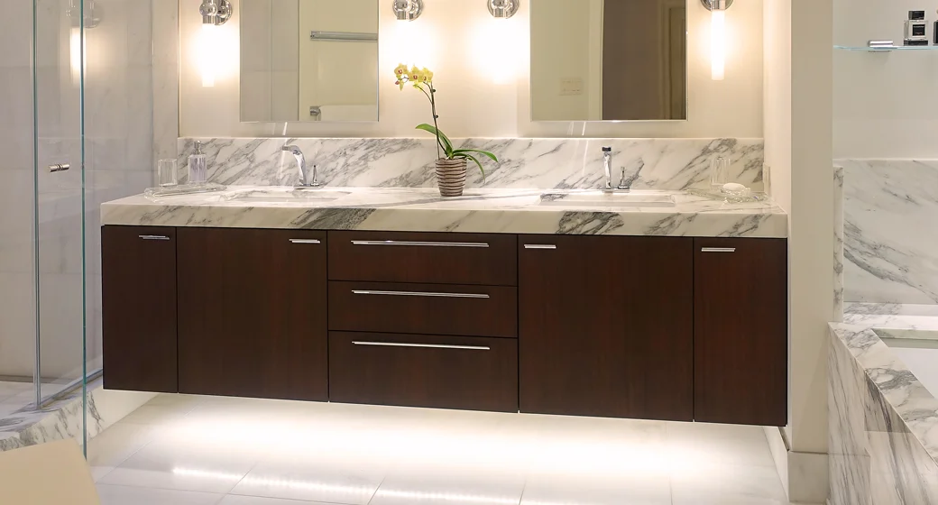 Sapele mahogany floating vanity, stained, with a clear finish. LED under-cabinet lighting and a white Carrara marble countertop. Potomac, MD
