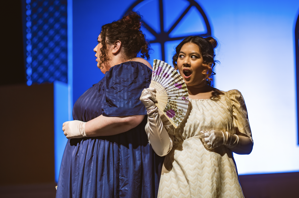  Anna Prelosky as Lizzy Bennet and Jauria Camacho as Charlotte Lucas in Kate Hamill’s  Pride and Prejudice.   Photo: Steph Balagot  Costumes: Christian Jay Santiago  Set and Lighting Design: Troy McVey 