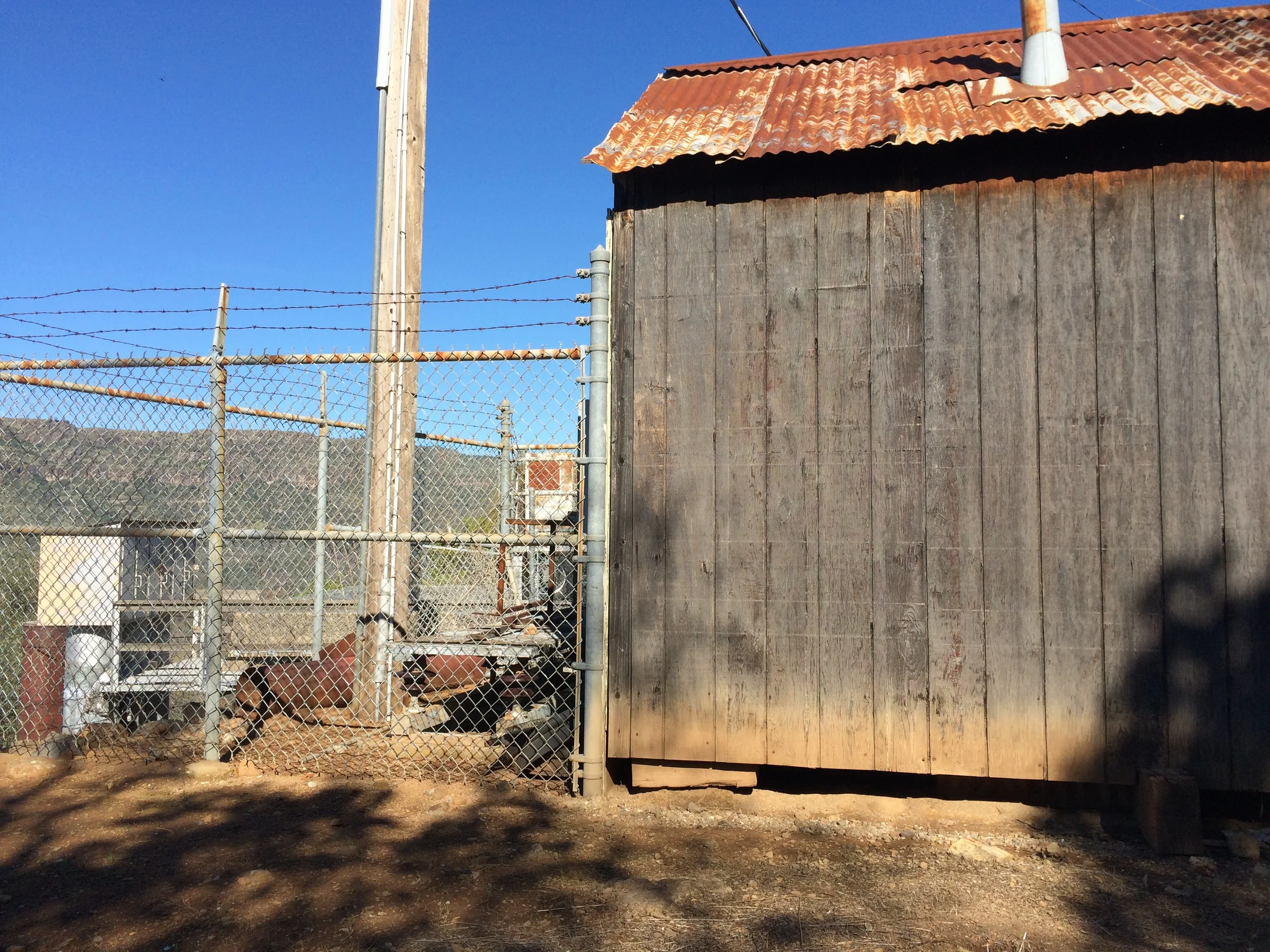  The flume trail dead ends at this collection of old machinery and single metal building. To continue on the dirt trail to the caves, walk past the building and you will see a trail leading up and slightly to the left. Take it! 