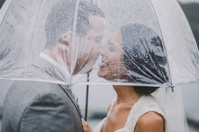 bride and groom under umbrella on a rainy wedding day