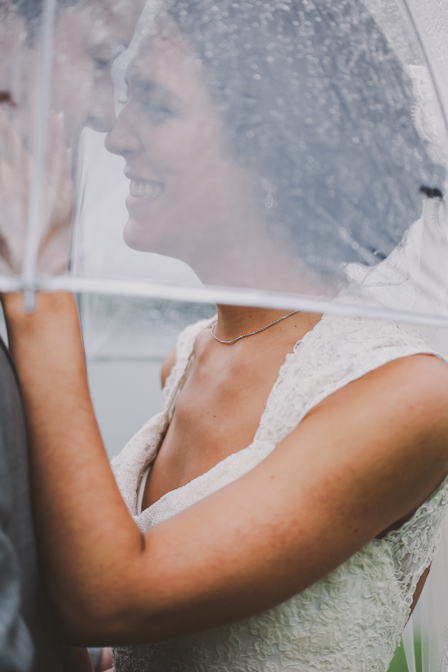 candid wedding couple pose in the rain