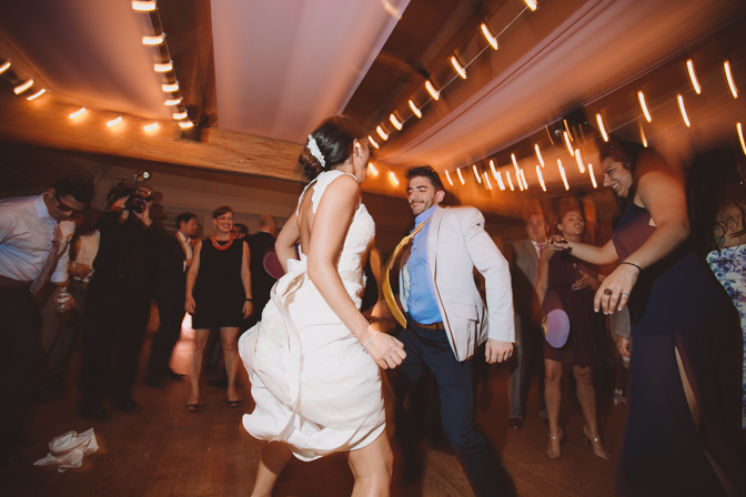 bride dancing with friends at wedding under christmas lights