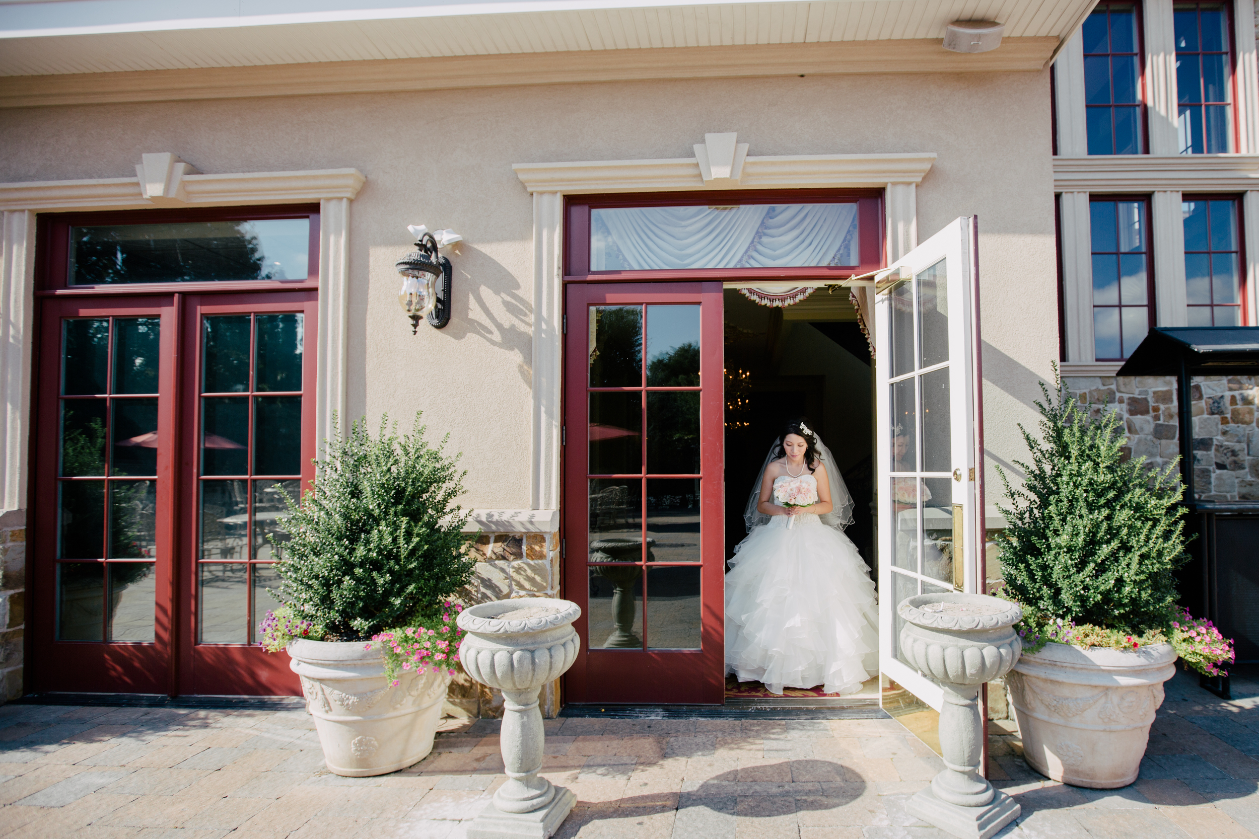 bride coming out the doors to go to the ceremony in queens