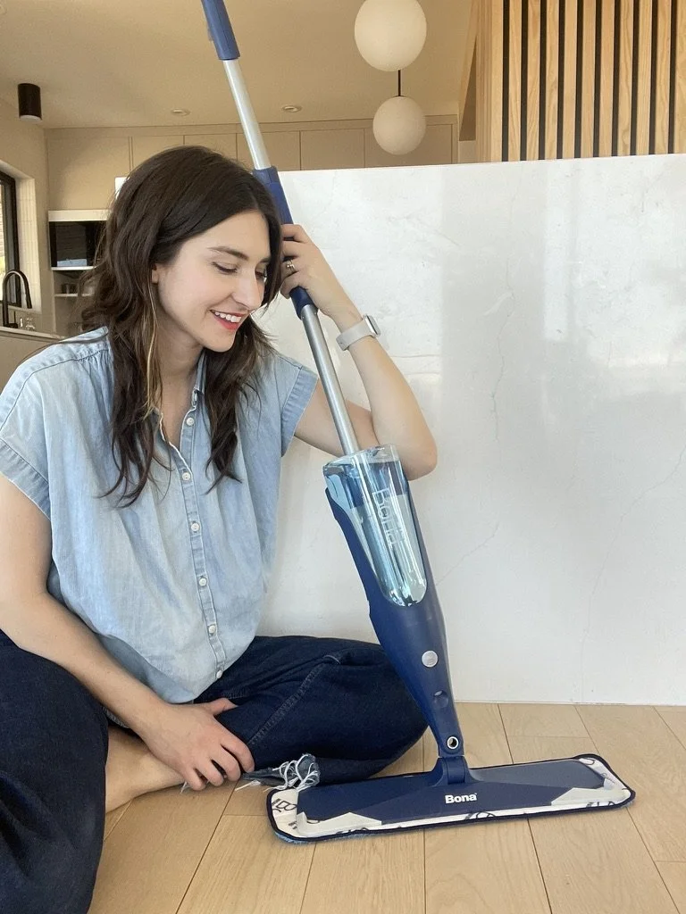 Britnee sitting on the floor with a Bona spray mop