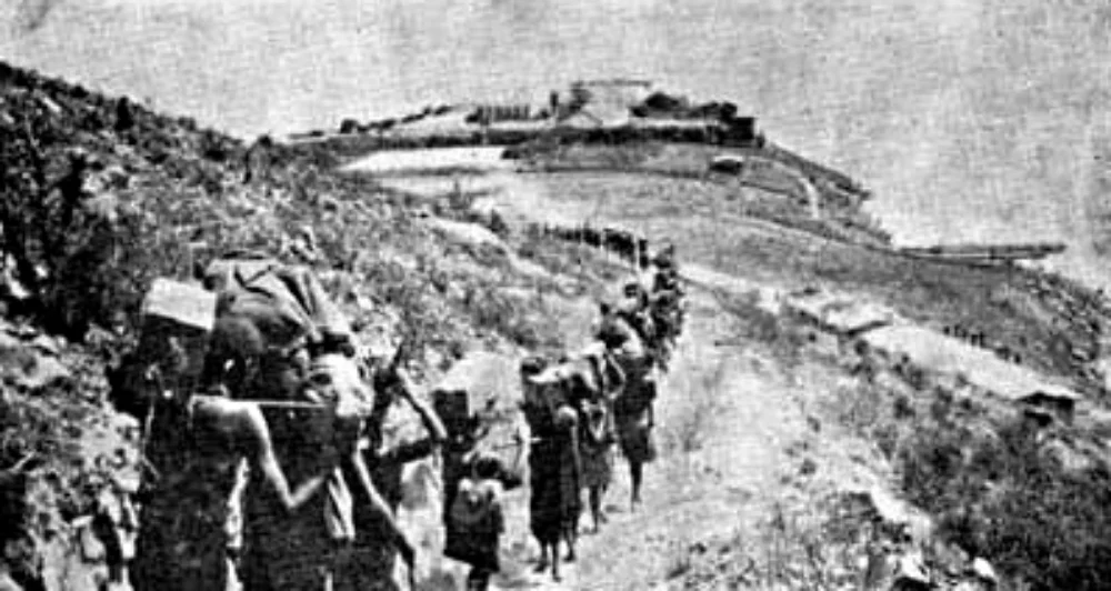 Carriers marching though Kasanga to Bismarkburg in WWI