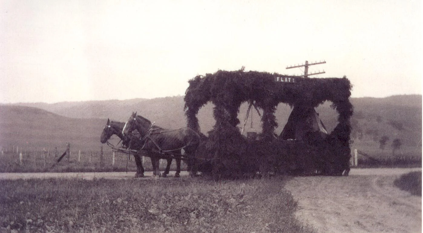 A parade float lines up in front of the farm as part of a local celebration.