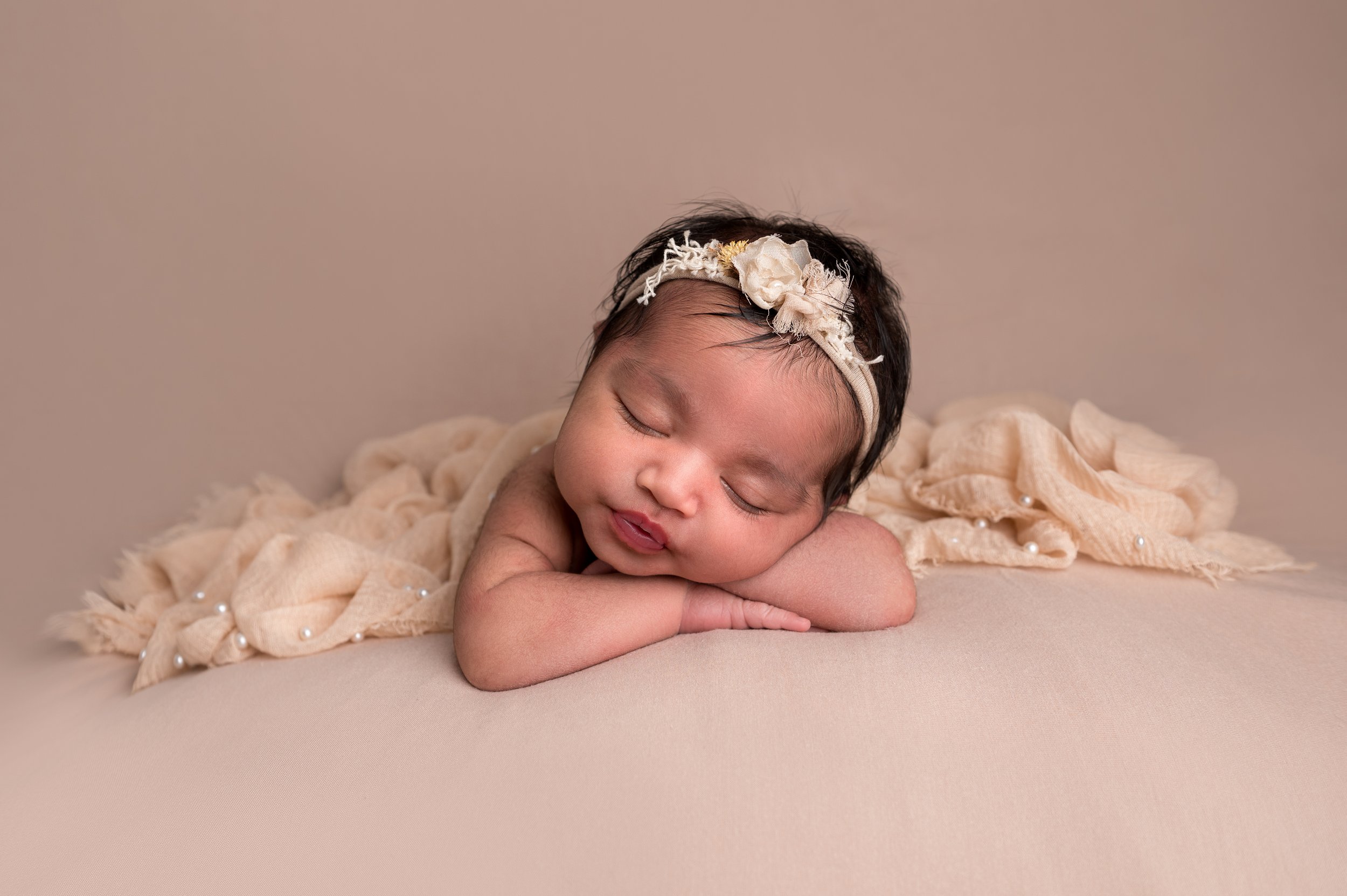 Baby girl on beige blanket