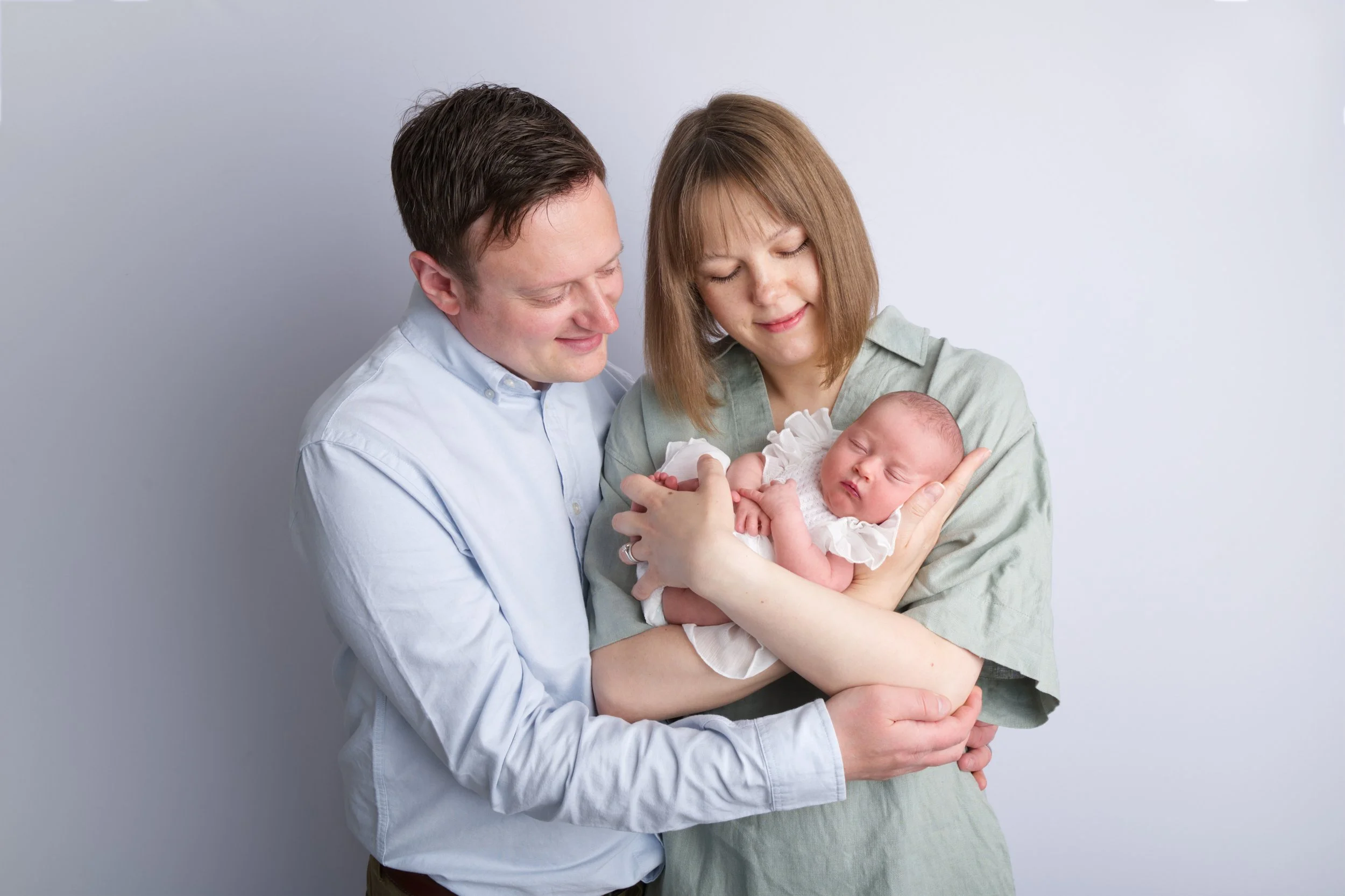 Parents with baby in white dress