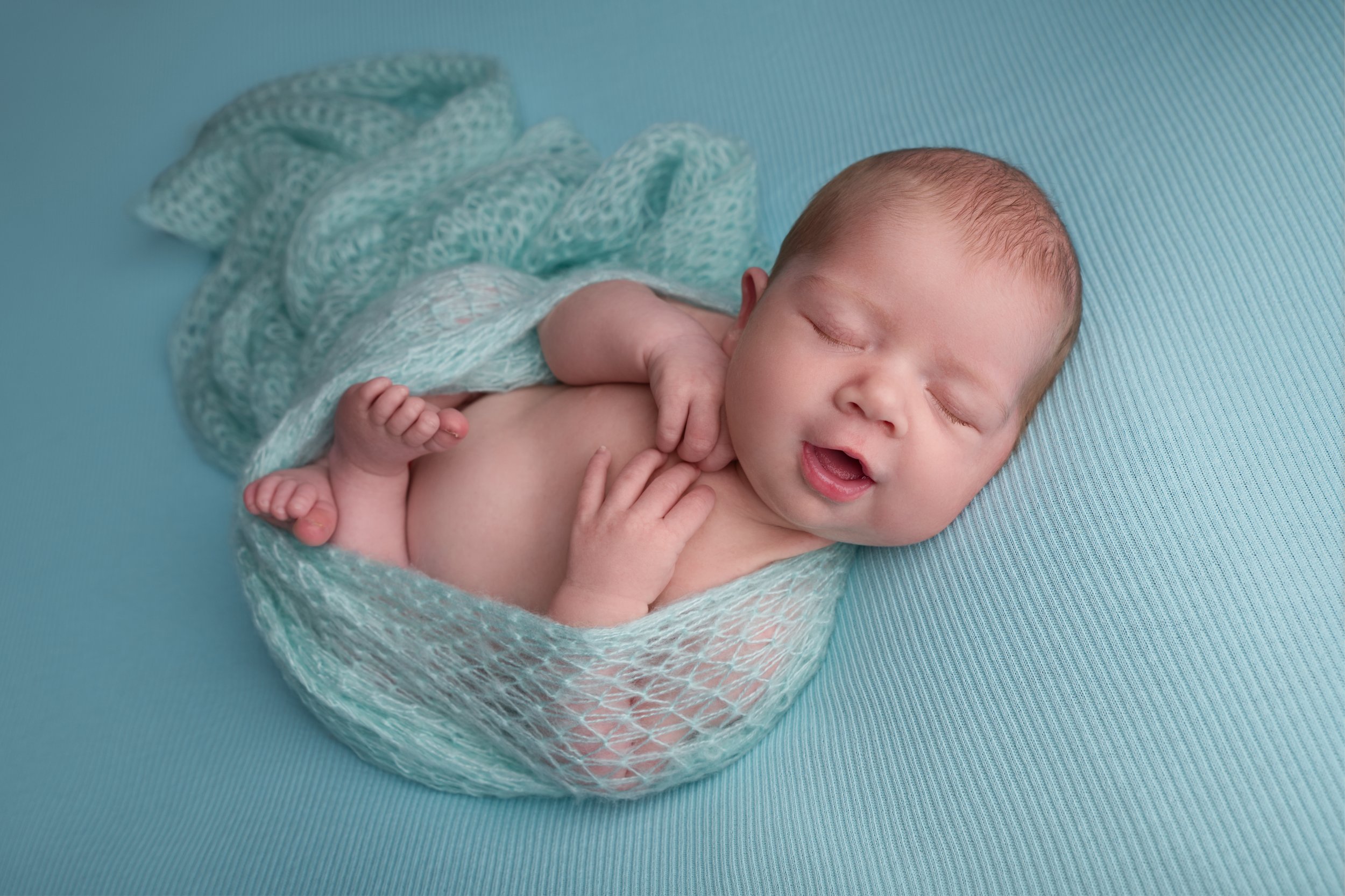 Baby swaddled in mint green