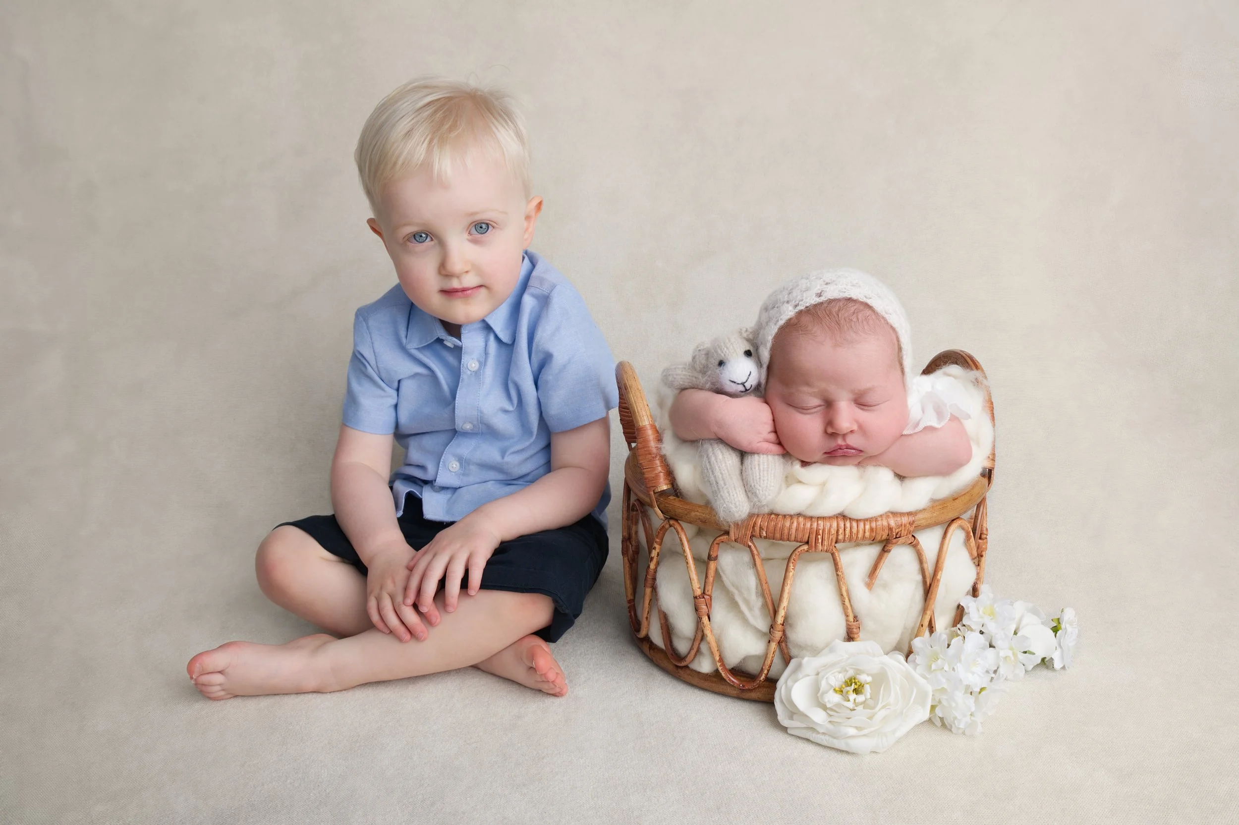 Big brother with baby sister in cream