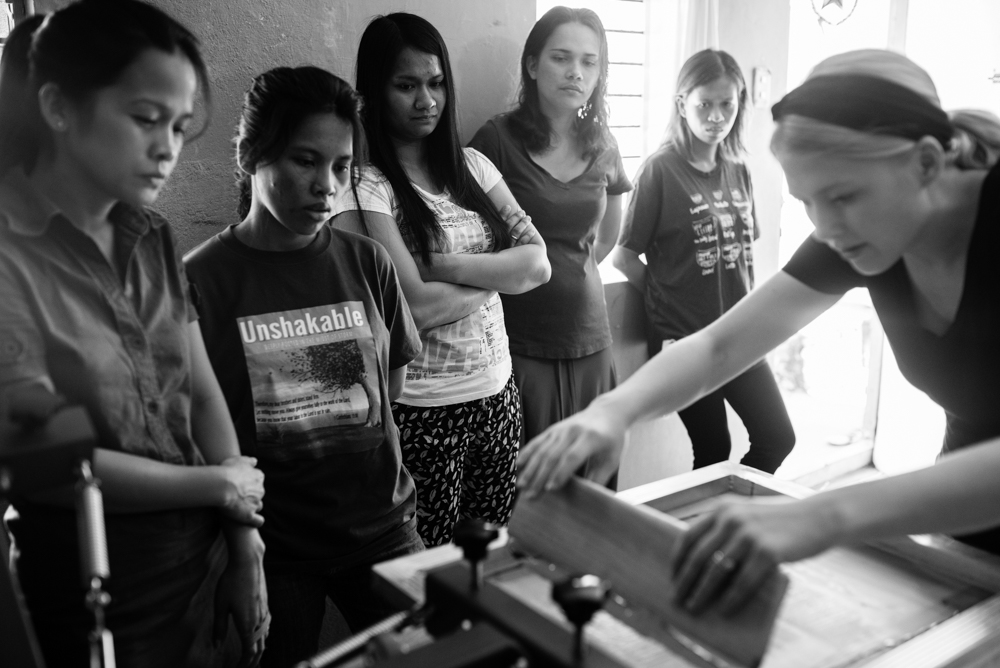 Hannah shows the staff how to use the screenprinting equipment