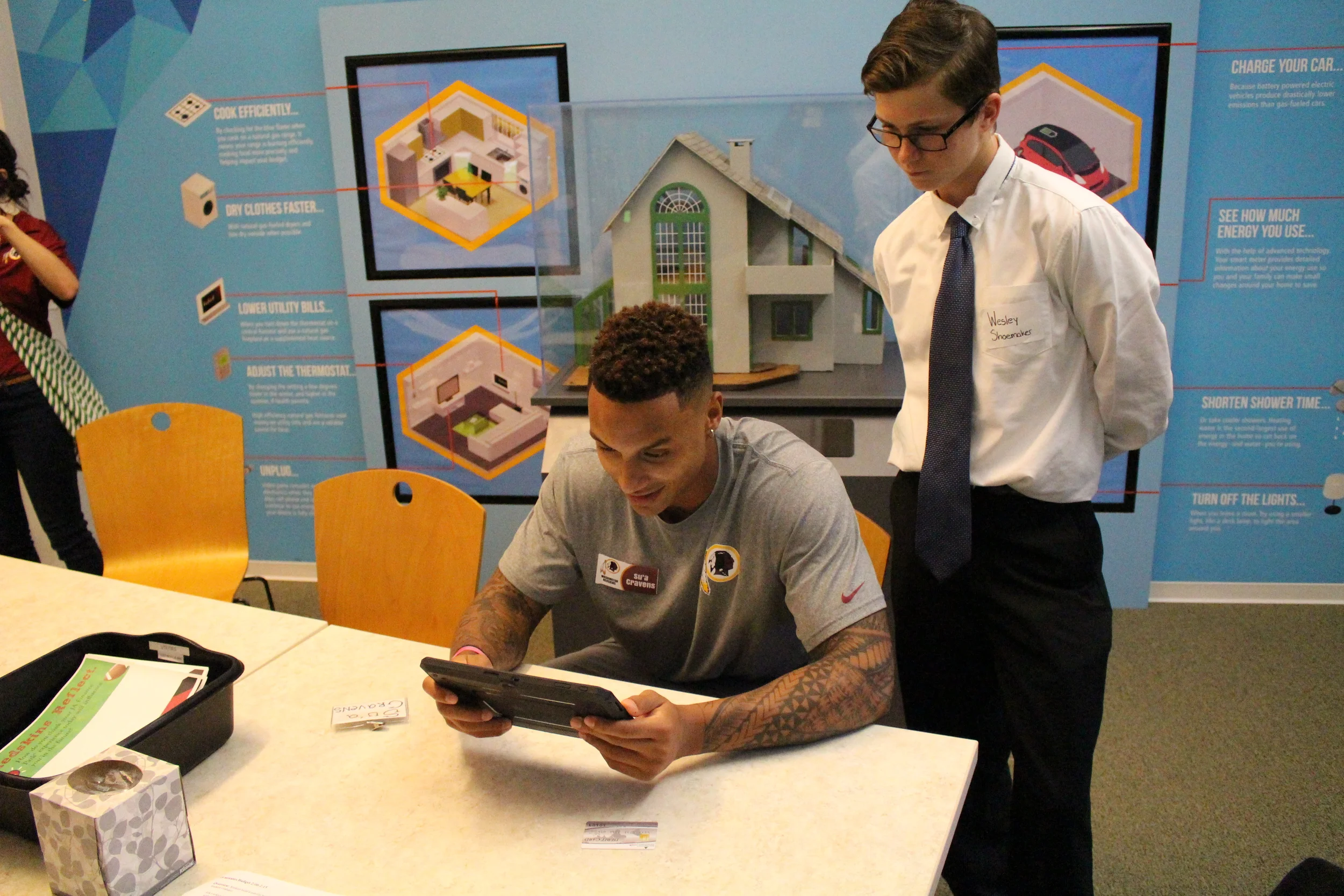Wesley Shoemaker leads Washington Redskins rookie Su'a Cravens through the JA Finance Park® budgeting simulation.