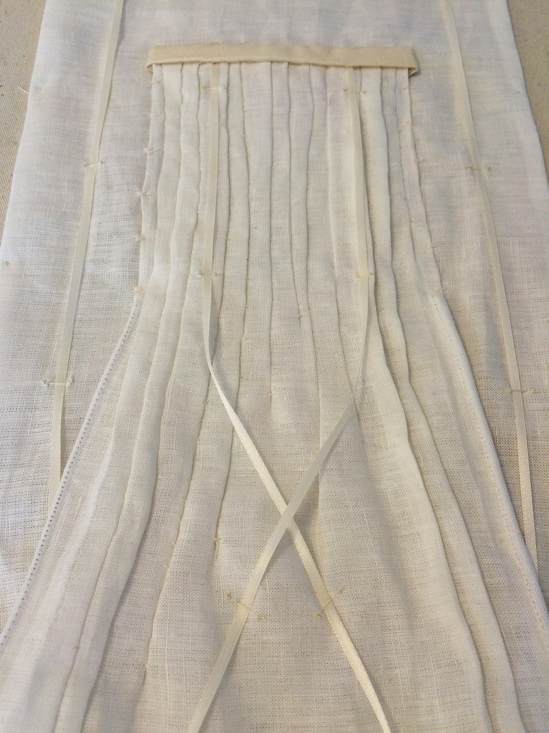 Detail of a three-dimensional white linen compositional wall-hanging. Now at the Frye Museum Store in Seattle, WA.