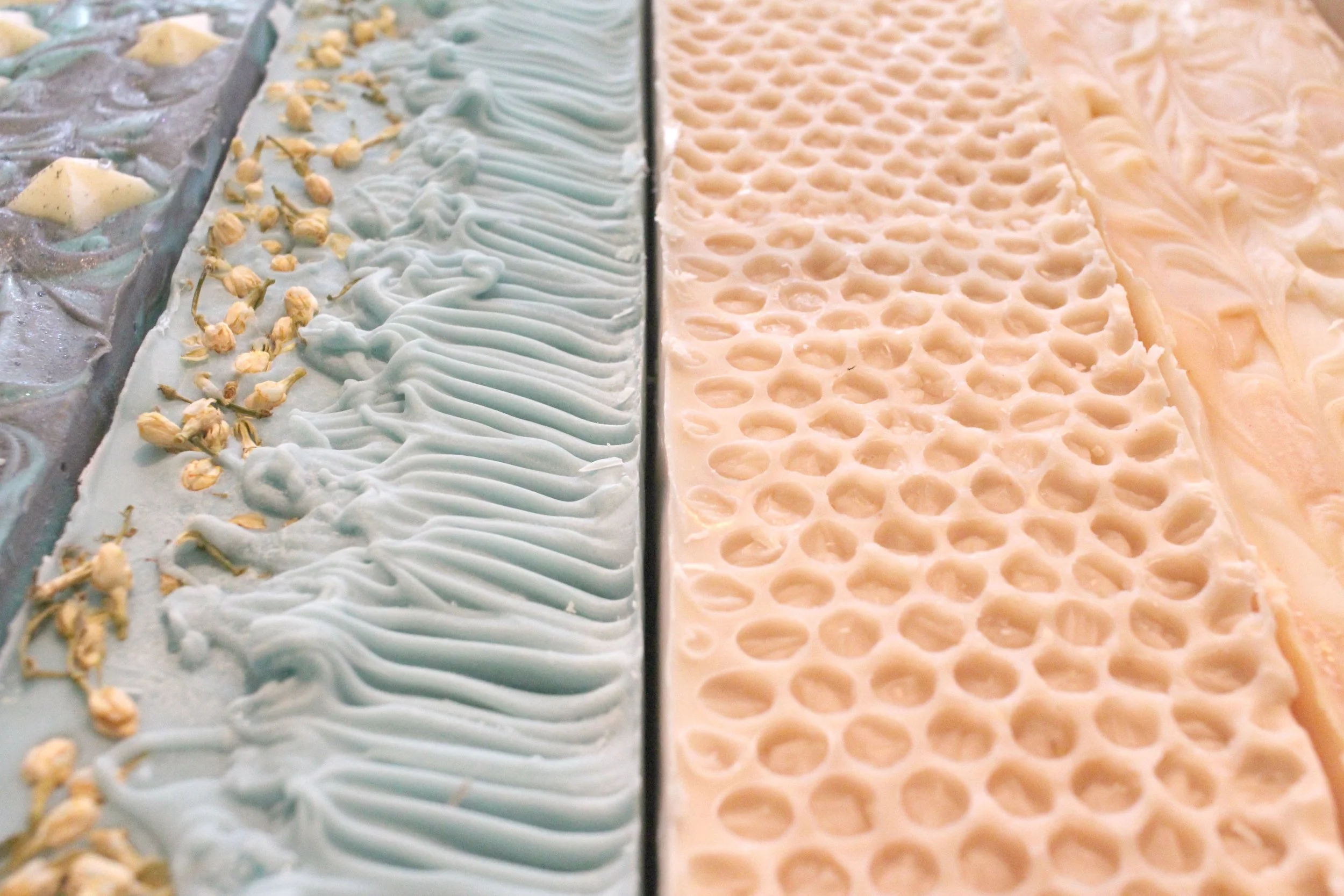 A variety of Artisan Cold Process Soaps. These Vegan bars have a variety of textured tops with stars, a beeswax pattern soap, and one with jasmine flowers
