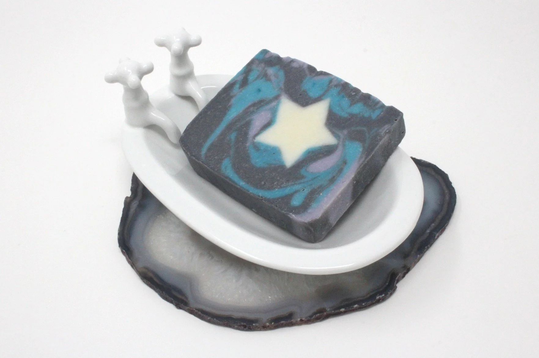 A Galactic Skies bar of soap. The soap is rectangular with a dark blue and black swirl and white star.