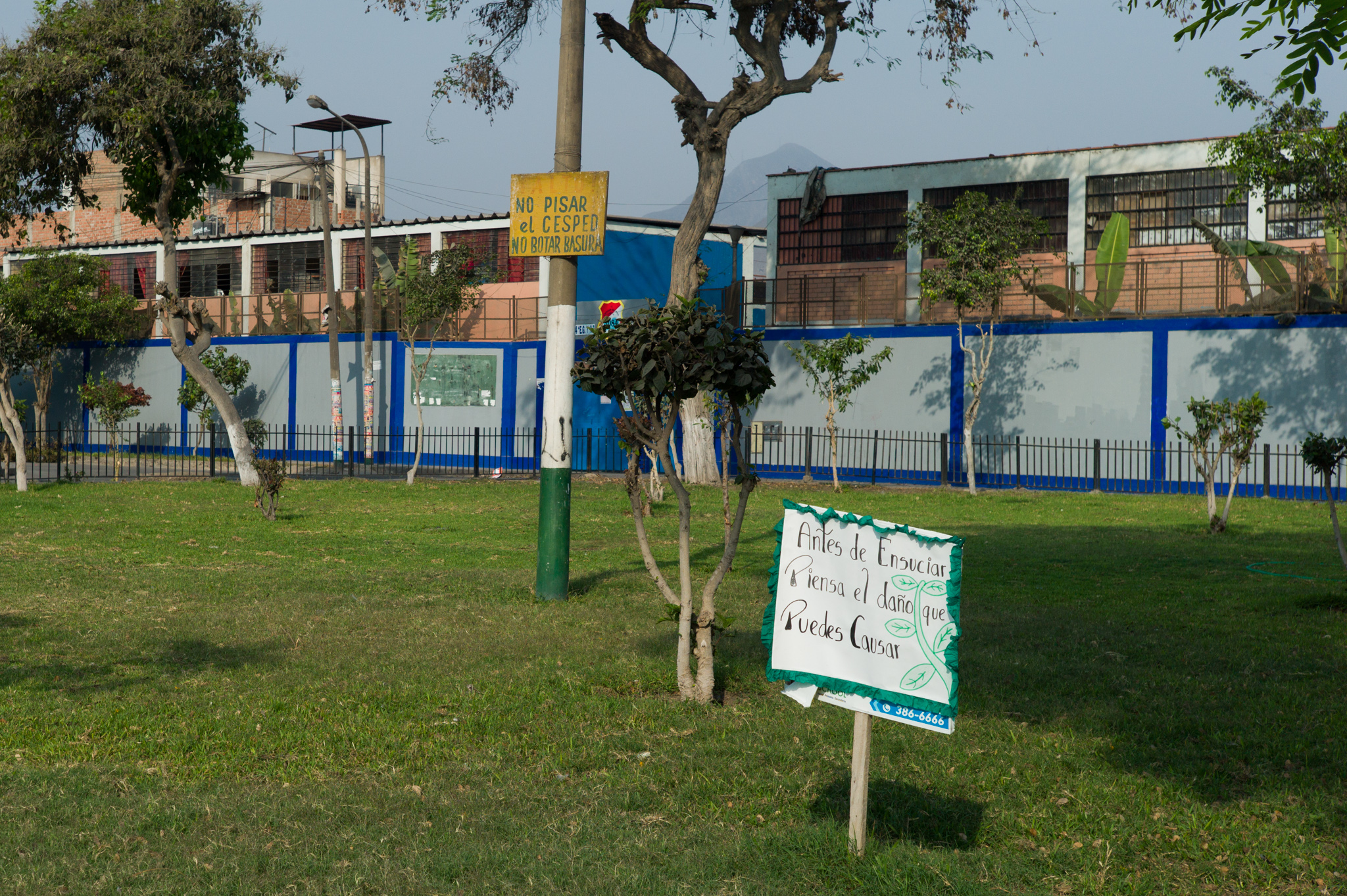  Another fenced park. The white sign reads "before making a mess, think of the damage you might cause." 
