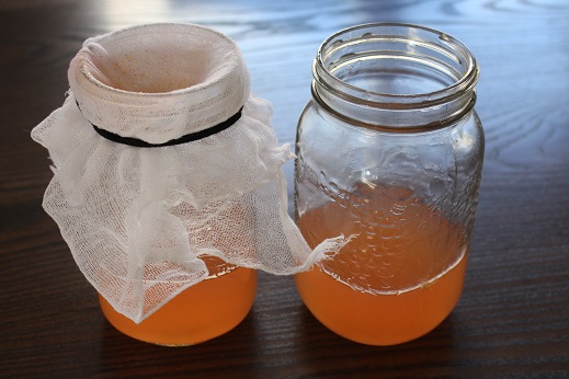 Extra step here to run it through the cheesecloth to filter further, removing strawberry seeds and small fragments of the orange that go through the funnel. 