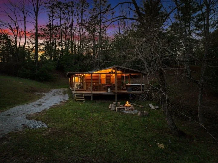 Front view of  The 1920's Ranch Cabin with fire pit lit in front