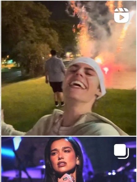 A young man smiling and laughing in the foreground with fireworks in the background, and a woman performing on stage below.