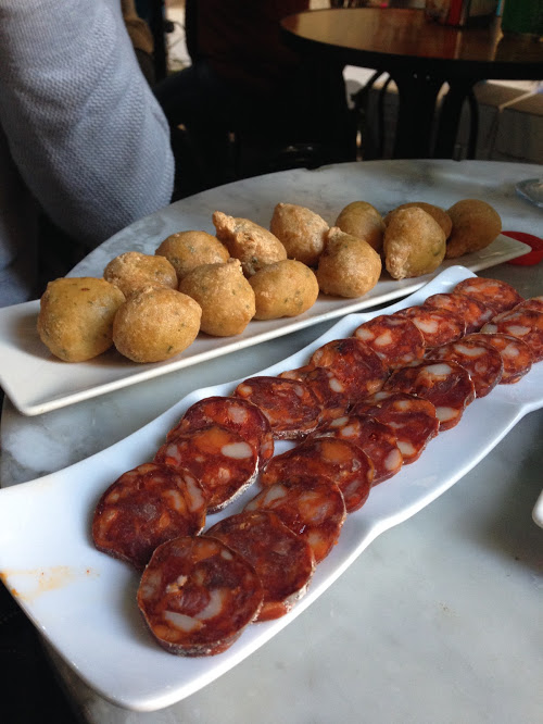 Some tapas of buñuelos de bacalao, or cod in fried batter, and chorizo, one of my favorite cold meats in Spain.