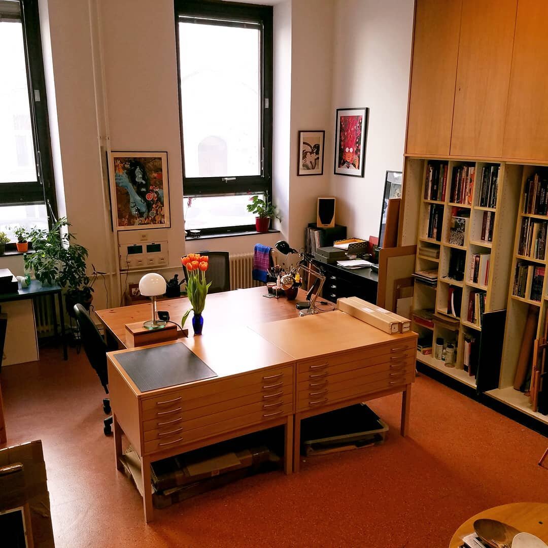 Here's what my studio looks like. 
I was prompted to finally take some decent photos of it, and since I can't share much else at the moment I thought these might be nice to show. 
The massive table is the center, where I do my real-media work. It's s