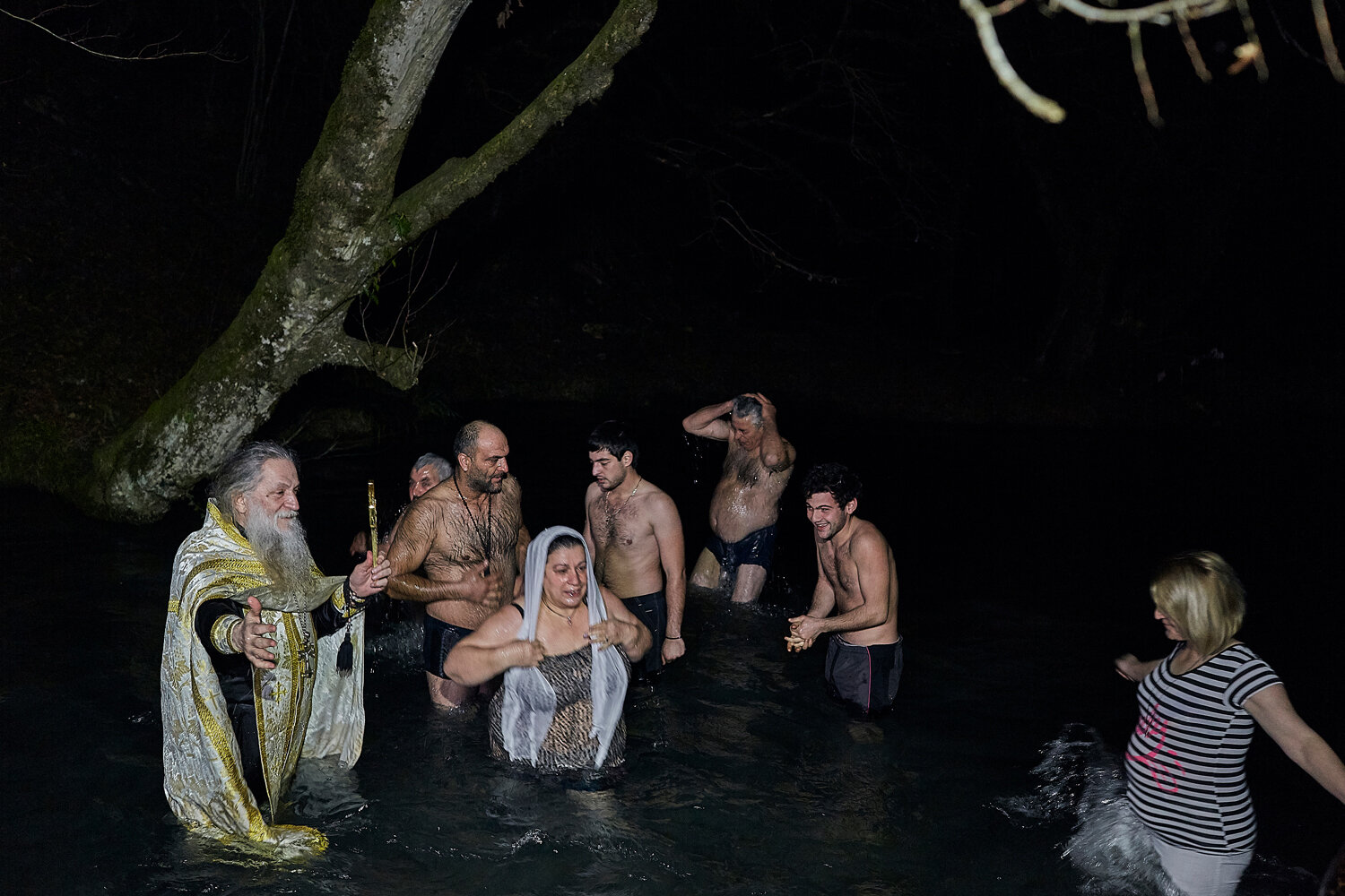  Abkhazia, Kamani village, 19/01/2016. Hegumen Ignatiy (Kiut) was standing in the cold water more than 20 minutes while people dipped into the blessed water. Festivities during the water is blessed in accordance with tradition of a Christian.  